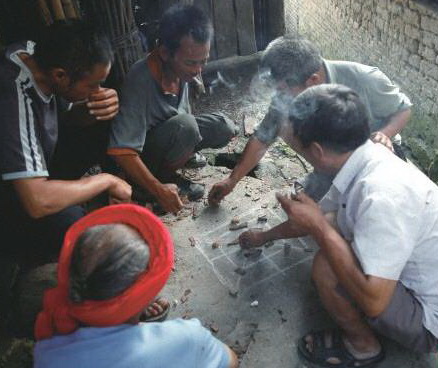 陰雨天,三五瑤民聚在一起玩瑤族傳統(tǒng)“趕豬棋”。